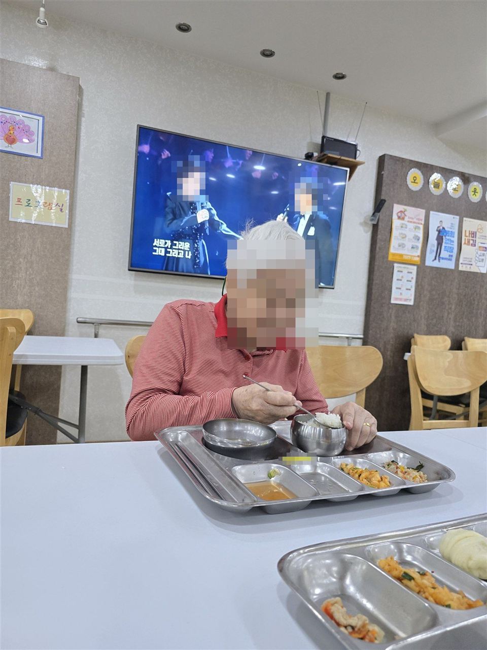 TV를 보며 식사하시는 어르신 (얼굴 모자이크)